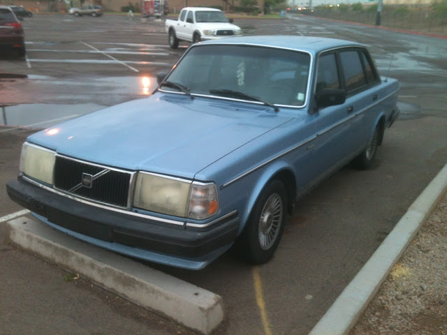 Blue 1986-1992 Volvo 240 GL sitting in parking lot after rainstorm