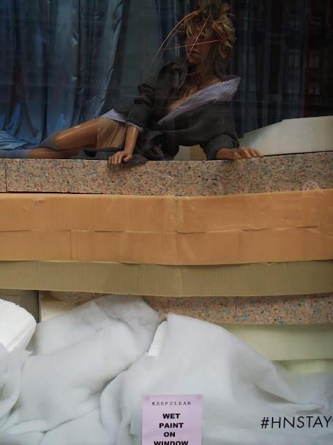 Sale window display with mannequin in feathered headpiece