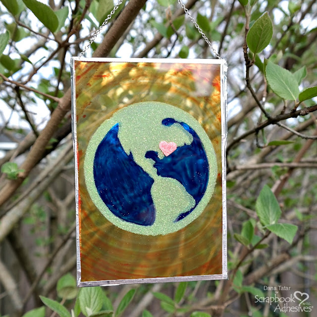 Upcycled Painted Glass Art with Blue and Green Earth, Glittery 3D Foam Heart, and Faux Soldered Frame Hanging in the Sun