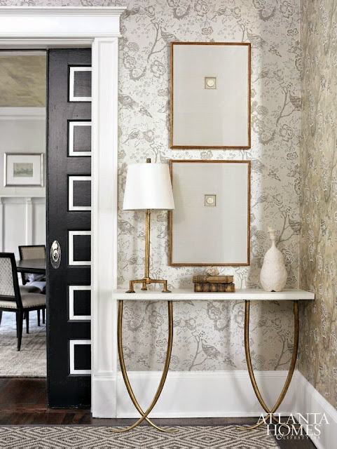 traditionally decorated white foyer black doors gold table wallpaper