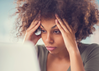 woman looking frustrated with head in hands trying to overcome writer's block