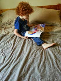 Boy sitting on Dormeo Memory Mattress reading a Christmas book