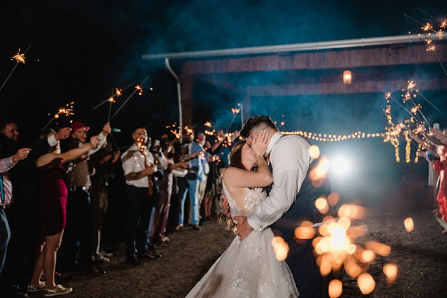 bride and groom kissing through sparklers