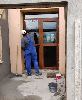 Halil cleans cement off the doors