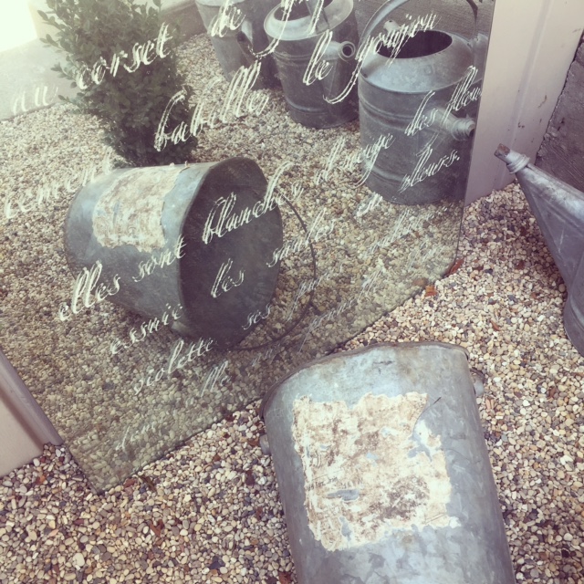 Stenciled mirror and galvanized bucket in gravel