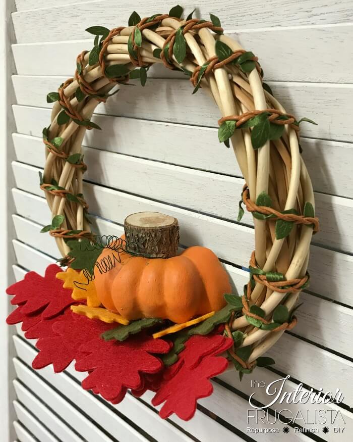 Turn inexpensive dollar store finds into an adorable small DIY Fall Pumpkin Wreath and it's so quick and easy to make in five minutes or less.