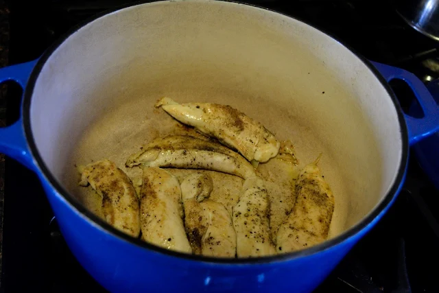 The chicken cooking in the soup pot.