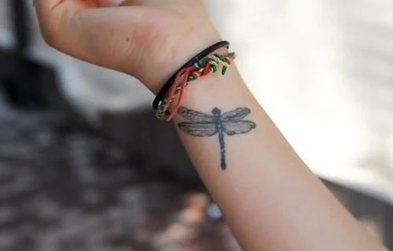 chica con un tatuaje de libelula muy femenino y detallado