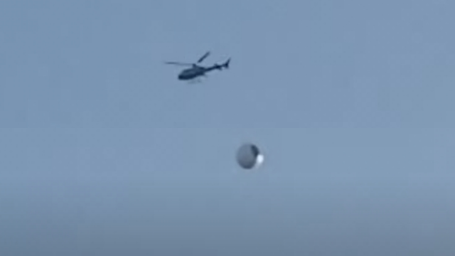Helicopter tried to get closer to a metallic ball UFO.