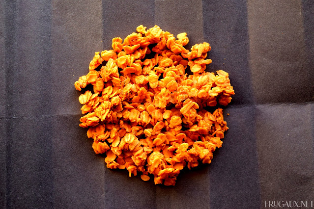 A circle of Cheese Pizza Granola sits on black folded paper.
