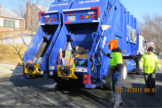 Two workers with their recycling truck.