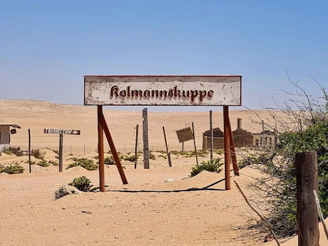 Kolmanskop sign at entrance to abandoned town in desert