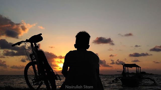 Setia menunggu mentari terbit di bibir pantai