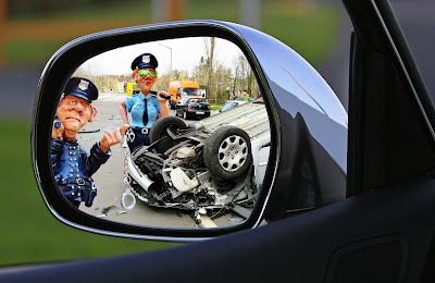 Two policemen in rear view mirror at an accident site