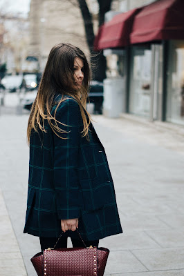 Mujer con pantalones negros y chaqueta de cuadros