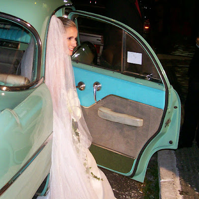 Novia bajando del coche llevando un velo