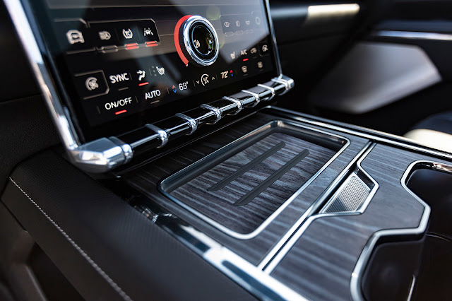 2024 GMC Sierra EV Denali Edition 1 - climate control and wireless smartphone charging under a wood cover.