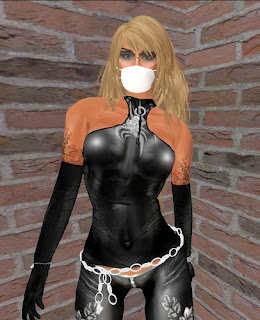 Tall, slender female avatar dressed in a tight, revealing black outfit with tattoos, gloves and blonde hair with a surgical-type mask covering her mouth.