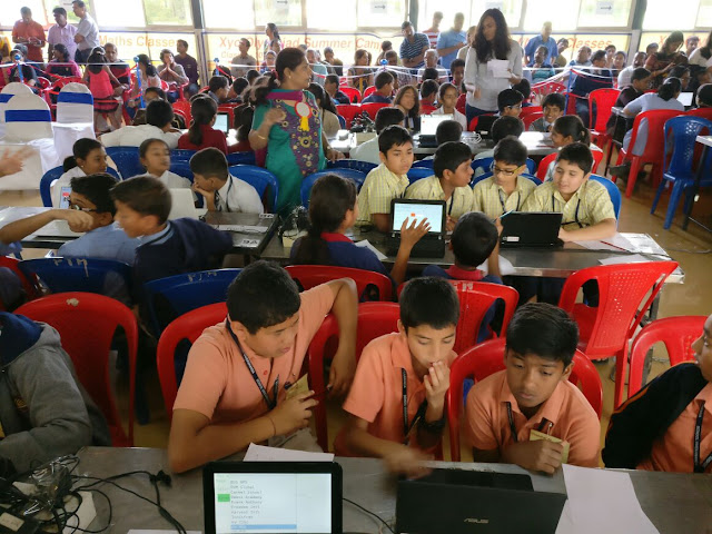 Students from various schools in Bangalore busy solving Maths-Science Olympiad in teams.  