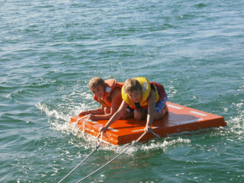 Boys having fun behind the boat