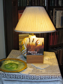 Beginning Nonviolence book on antique reading table with lamp.