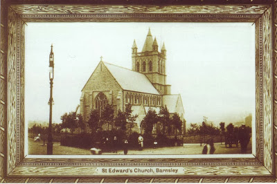 A postcard showing a single aisled church with square tower topped with a little spire.  There are some small new looking trees around the church and a gas lamp in the foreground