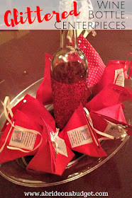 Need a wedding centerpiece or engagement party centerpiece idea? Check out these Glittered Wine Bottle Centerpieces on www.abrideonabudget.com. #glitter #winebottlecraft #winebottlecenterpiece #diyglitteredwinebottle