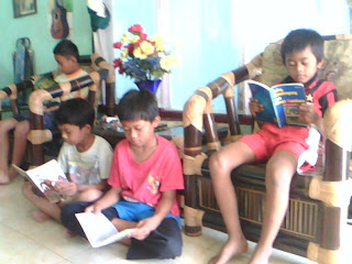 Anak-anak sedang asyik membaca buku cerita dongeng