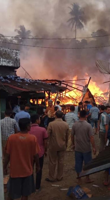 Warga menyaksikan rumah peninggalan Raja Mandina yang terbakar.