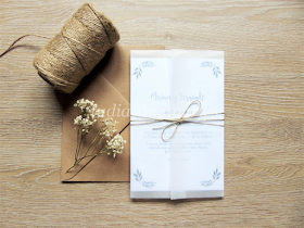 Decora las invitaciones de boda con materiales naturales como el cordón o papel cebolla