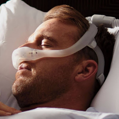 man sleeping with nasal cpap machine