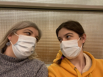 You and I looking at each other with our masks on while waiting for the ophthalmologist to call you back to his room. I am wearing a blue sweater with my hair down and you are wearing your yellow sweater with your hair braided.