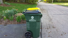 trash and recycling containers at curbside on a warmer day