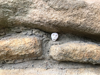 A photo showing the wall of Durham Tower, and in a gap there is a small ceramic skull (Skulferatu 99).  Photo by Kevin Nosferatu for the Skulferatu Project.