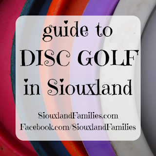 in background, the bottoms of  five disc golf discs form graphic stripes. in foreground, the words "guide to disc golf in Siouxland" and "SiouxlandFamilies.com Facebook.com/SiouxlandFamilies"