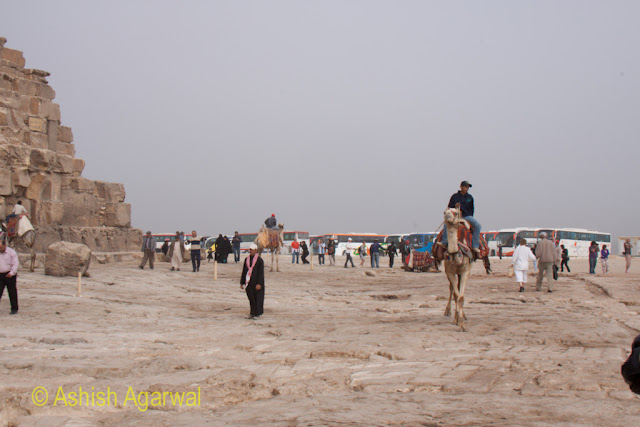 Cairo Pyramid - Tourists riding camels right next to the Great Pyramid in Giza