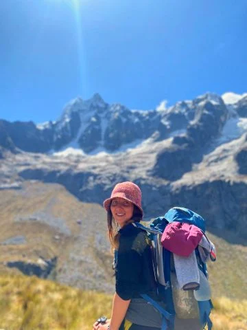 Ragazza durante trekking ai piedi di monti nevati