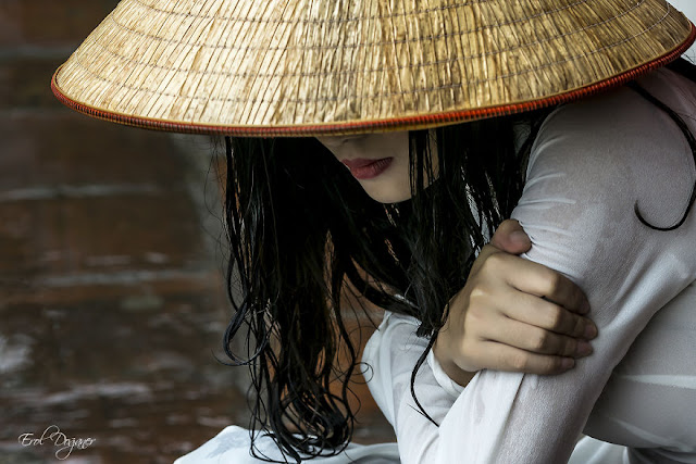 Một cô gái trẻ mặc áo dài truyền thống ngồi trong mưa - Ảnh: Erol Doğaner