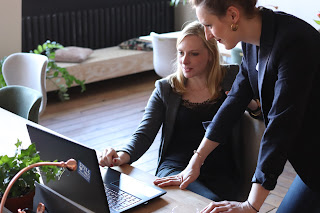 A woman and man staring at a computer screen | collection agency Kentwood