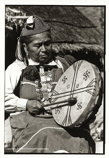 Mapuche woman with a drum with four-armed and six-armed swastika-like spirals.