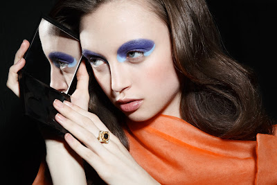 woman looking into mirror, purple eyeshadow, creative makeup, edgy makeup