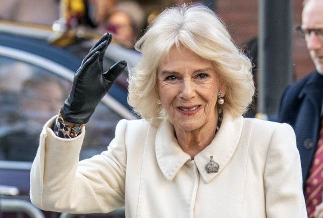 Queen Camilla wore a white wool and cashmere midi coat, and floral print midi dress, black leather clutch and suede boots