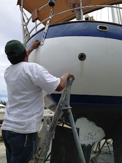 Roberto's assistant buffs the touch-up paint on Whispering Jesse's stern