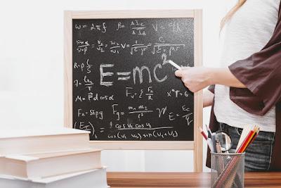 Chalkboard with equations and teacher