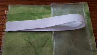 The inner piece of fabric with the plastic pocket sewn on. On the other end of the fabric, there is a loop of the strap.