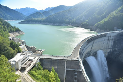 観光放水中の黒部ダムと黒部湖、赤牛岳