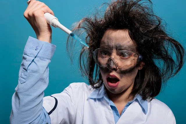 A woman researcher looking shocked at a pipette tip filled with experimental liquid substance.