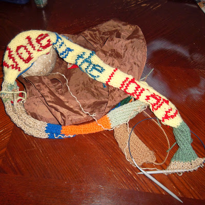 Multicolored length of knitting on circular knitting needles, with phrase "Vote For the Library"