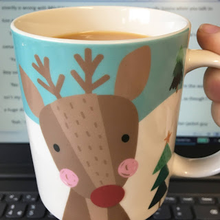 Rudolph mug in front of laptop