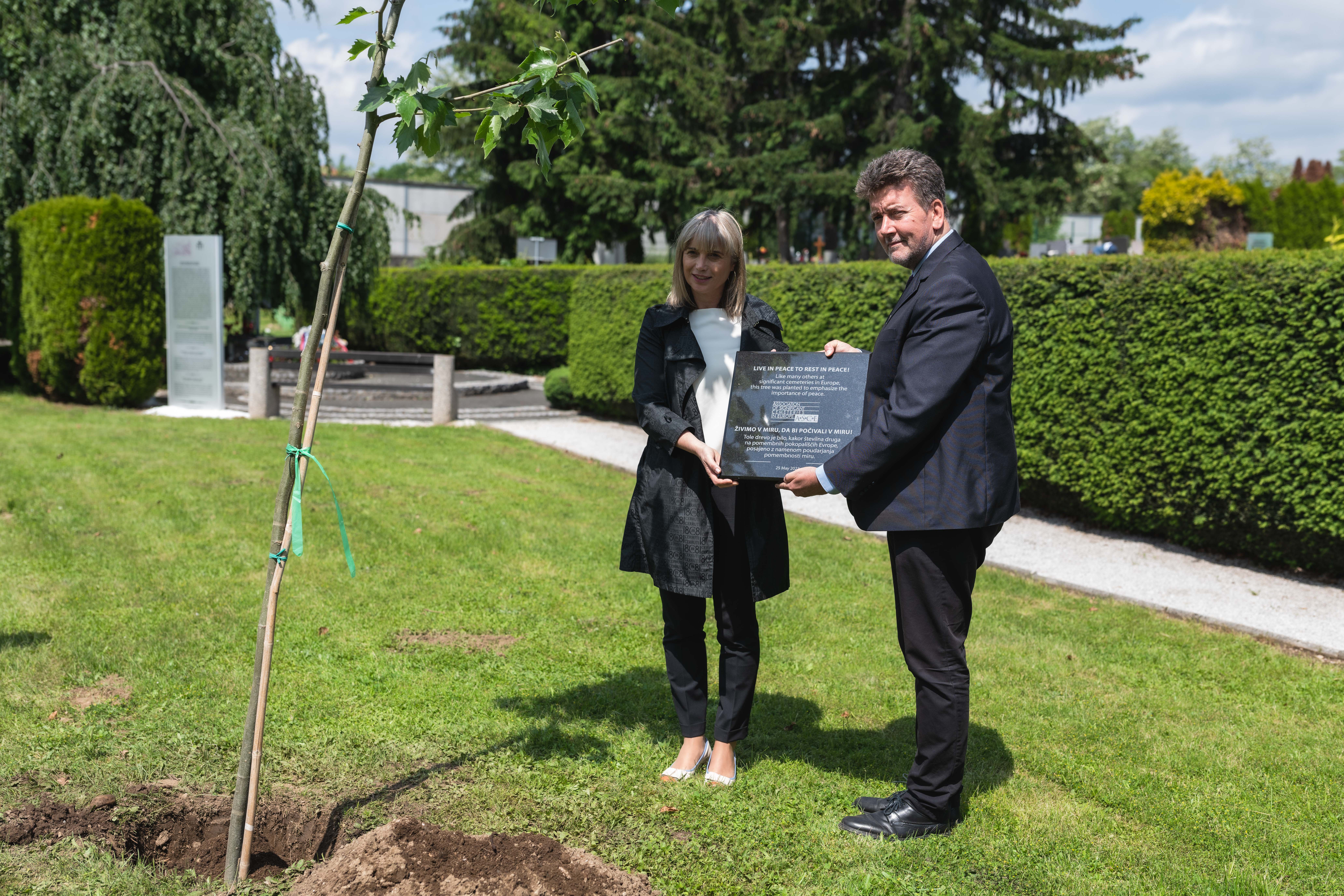 Mrs Lidija Pliberšek and Mr Móczár Gábor Attila planting a tree at Pobrežje Cemetery.